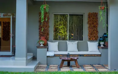 a bench on the front of a house with a window at Tulivu Kilimanjaro Retreat in Moshi