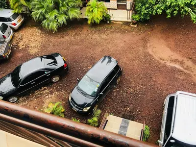 two cars parked in a dirt parking lot at Kilimanjaro Smiley Inn in Moshi