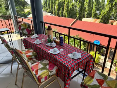 a table with cups and saucers on a balcony at Kilimanjaro Smiley Inn in Moshi