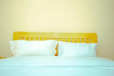 a bed with white sheets and pillows at BCB Homes in Moshi