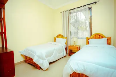 a bedroom with two beds and a window at BCB Homes in Moshi