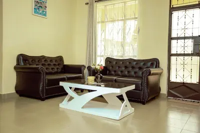 a living room with two leather couches and a coffee table at BCB Homes in Moshi