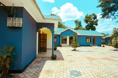 a house with blue walls and a courtyard at BCB Homes in Moshi