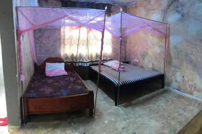 a bedroom with two beds with a canopy at Kilibase Hotel in Moshi