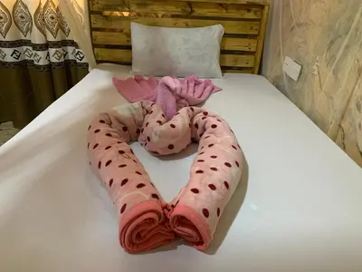 a heart made out of towels on a bed at Kilibase Hotel in Moshi