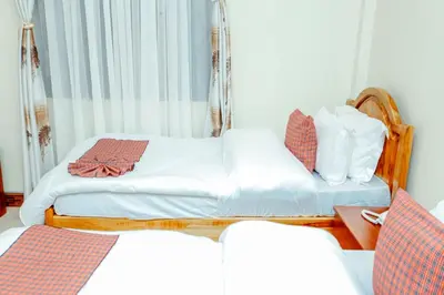 a bedroom with two twin beds and a table at CM Luxury Lodge in Moshi