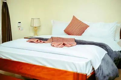 a large white bed with two bow ties on it at CM Luxury Lodge in Moshi