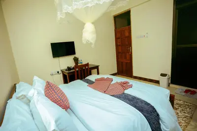 a bedroom with a bed with two stuffed animals on it at CM Luxury Lodge in Moshi