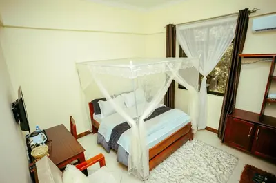 a bedroom with a bed with a canopy at CM Luxury Lodge in Moshi