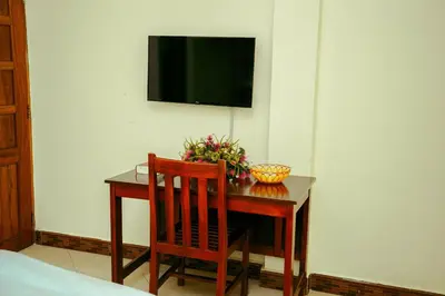 a table with two chairs and a television on a wall at CM Luxury Lodge in Moshi