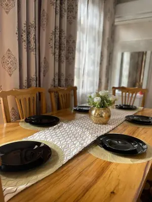 a wooden table with black plates on top of it at NAURA HOMESTAYS in Arusha