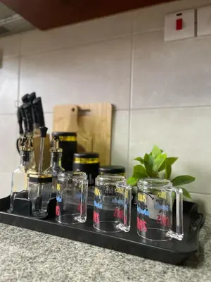 a tray with glasses and bottles on a counter at NAURA HOMESTAYS in Arusha
