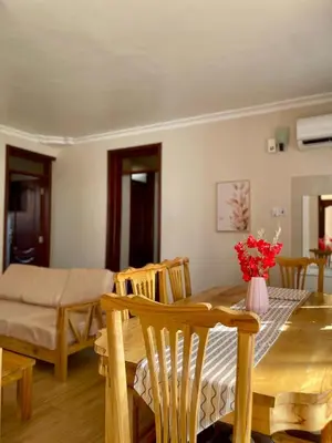 a dining room and living room with a table and chairs at NAURA HOMESTAYS in Arusha