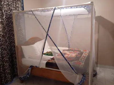 a small bed with a canopy in a room at The Secret Garden Hotel Moshi in Moshi