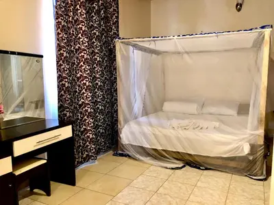 a bed with a canopy in a room at The Secret Garden Hotel Moshi in Moshi