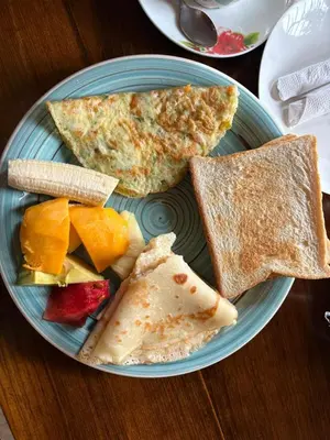 a blue plate of breakfast food with toast and fruit at The Secret Garden Hotel Moshi in Moshi