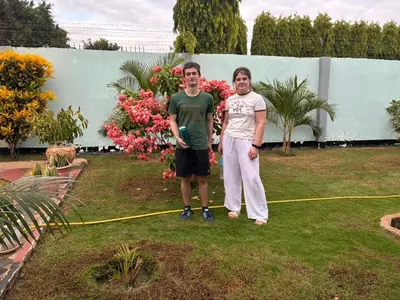 two men standing in a yard with a hose at The Secret Garden Hotel Moshi in Moshi