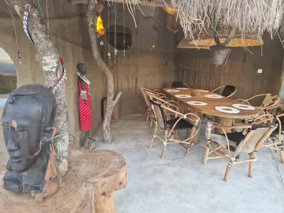 a wooden dining room with a table and chairs at Original Maasai Lodge – Africa Amini Life in Ngare Nanyuki