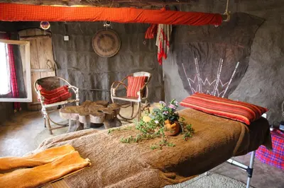 a bedroom with a bed and chairs in a room at Original Maasai Lodge – Africa Amini Life in Ngare Nanyuki
