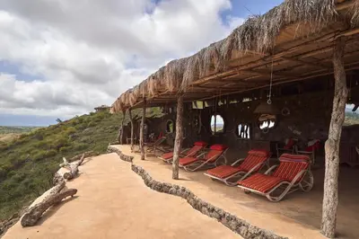 a group of chairs sitting on a porch of a hut at Original Maasai Lodge – Africa Amini Life in Ngare Nanyuki