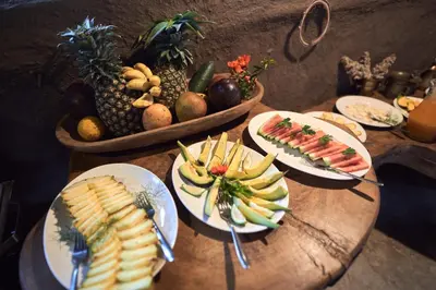 a wooden table with plates of food on it at Original Maasai Lodge – Africa Amini Life in Ngare Nanyuki