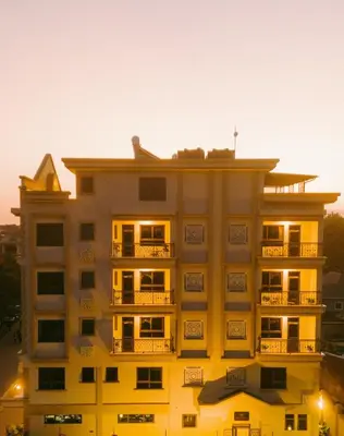 a yellow building with a sunset in the background at Westwood Residences in Arusha