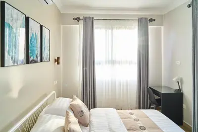 a bedroom with a bed and a window and a desk at Westwood Residences in Arusha
