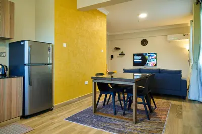 a kitchen and dining room with a table and a refrigerator at Westwood Residences in Arusha