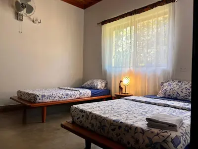 two beds in a room with a window at Walk With Us Africa in Moshi