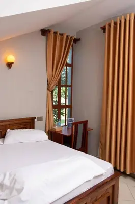 a bedroom with a white bed and a window at Simba Villa in Arusha