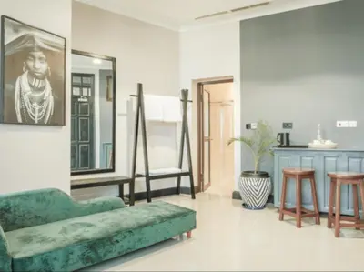 a living room with a green couch and a mirror at Sanna Boutique Hotel in Arusha