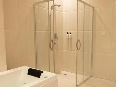 a shower with a glass enclosure in a bathroom at Sanna Boutique Hotel in Arusha