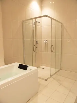 a bathroom with a shower and a bath tub at Sanna Boutique Hotel in Arusha