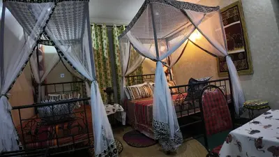 a bedroom with two beds with mosquito nets at Korona Villa Lodge in Arusha