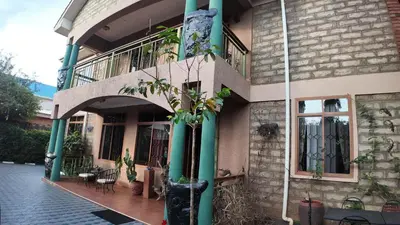 a building with a balcony with a potted plant on it at Korona Villa Lodge in Arusha