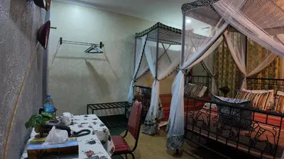 a room with a bedroom with a bed and a table at Korona Villa Lodge in Arusha