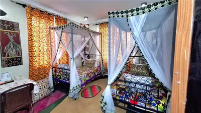 a room with two bunk beds and curtains at Korona Villa Lodge in Arusha