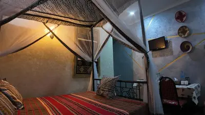 a bedroom with a canopy bed in a room at Korona Villa Lodge in Arusha