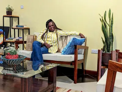 a man sitting on a chair in a room at Mvuli Hotels Arusha in Arusha