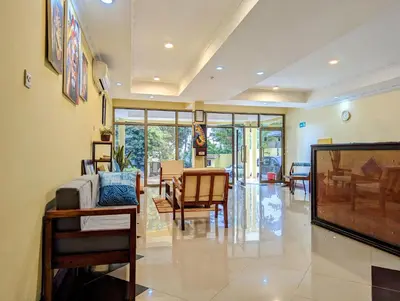 a living room with a tv and a table and chairs at Mvuli Hotels Arusha in Arusha