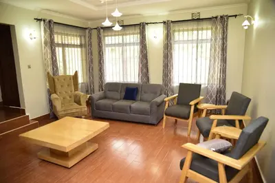 a living room with a couch and chairs and a table at EMALI ARUSHA HOME in Arusha