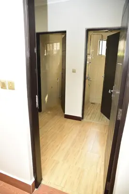 a hallway with two doors and a wooden floor at EMALI ARUSHA HOME in Arusha