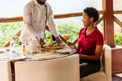 a man and a woman sitting at a table with a plate of food at Tulia Boutique Hotel & Spa in Arusha