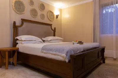 a bed in a bedroom with plates on the wall at Tulia Boutique Hotel & Spa in Arusha