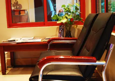 a chair sitting in front of a desk with a mirror at Mc-Elly's Hotel in Arusha