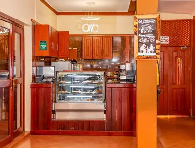 a kitchen with wooden cabinets and a counter with a refrigerator at New Safari Hotel in Arusha