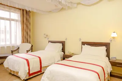 a hotel room with two beds and a window at New Safari Hotel in Arusha