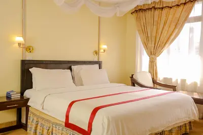 a bedroom with a large bed and a window at New Safari Hotel in Arusha