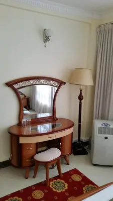 a desk with a mirror and a lamp in a room at Corridor Springs Hotel in Arusha