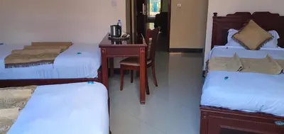 a room with two beds and a desk with a computer at Corridor Springs Hotel in Arusha